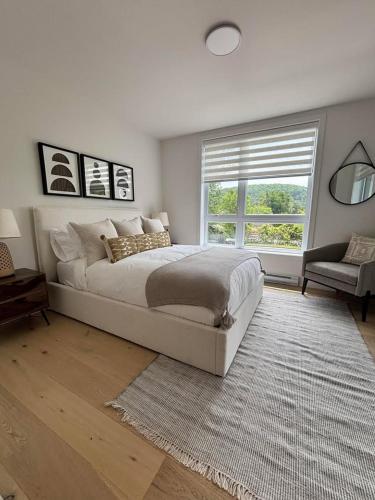 a bedroom with a large bed and a window at Le 800 de St-Jovite in Mont-Tremblant
