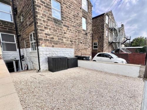 a car parked in front of a brick building at Eleven on Dragon - Boutique Hotel Rooms & Studio Apartment in Harrogate