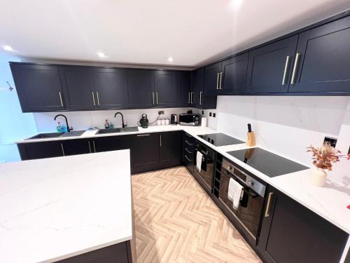a kitchen with black cabinets and white counter tops at Eleven on Dragon - Boutique Hotel Rooms & Studio Apartment in Harrogate