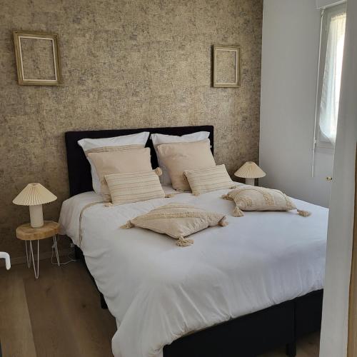 a large bed with white sheets and pillows at Maison familiale à Fouras-Plage & centre à pied in Fouras