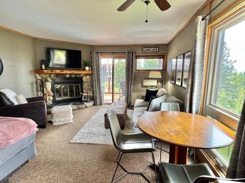 a living room with a table and a fireplace at Ski in Ski out Cozy Studio Condo, Pool, Hot Tub, Views of Moose Mtn in Lutsen