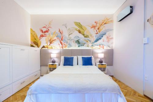 ein Schlafzimmer mit einem großen Bett mit blauen Kissen in der Unterkunft Buen Viaje Mendoza in Mendoza