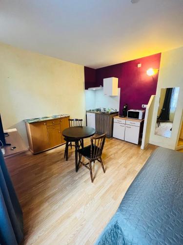 a living room with a table and a kitchen at Ludotel in Belley