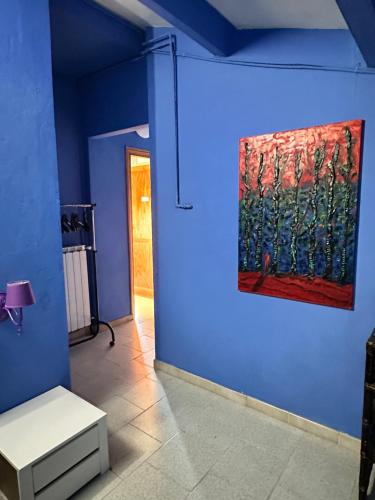 a blue room with a painting on the wall at Studio Della Fiamma in Gubbio