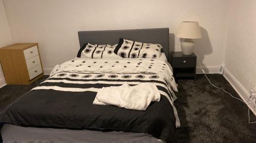 a bedroom with a bed and a night stand with a lamp at Olivetem Comfort House in Bolton
