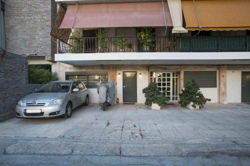 a car parked in a parking lot in front of a building at Ilissos Harmony Apartment in Piraeus