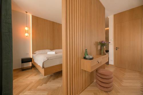 a bedroom with a bed and a wooden wall at 1779 SUITES Kežmarok in Kežmarok