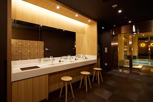 a bathroom with three sinks and a large mirror at Candeo Hotels Matsuyama Okaido in Matsuyama