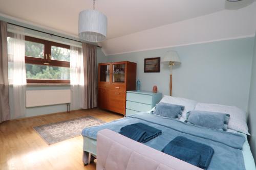 a bedroom with a bed and a couch and a window at Dom pod Górskim Niebem in Kobiernice