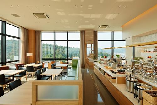 松山市にあるカンデオホテルズ 松山大街道店 のテーブルと椅子と窓のあるレストラン