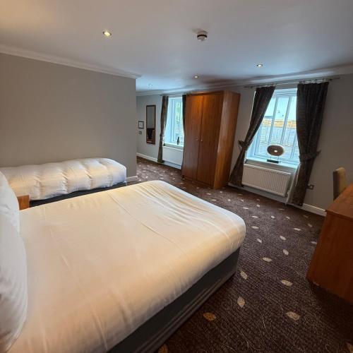 a hotel room with two beds and a window at Plas Derwen Hotel in Abergavenny