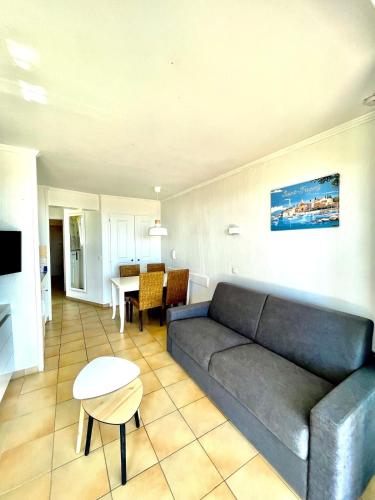 a living room with a couch and a table at Restanques appartement vue mer in Grimaud