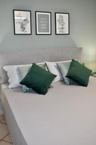 a bed with green and white pillows on it at La Ca Rosa in Cardano al Campo
