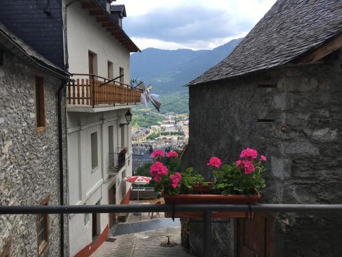 a balcony with pink flowers on a building at Casa Rural Cuny in Casau