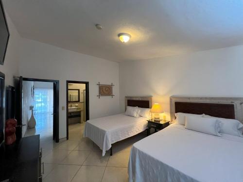 Una cama o camas en una habitación de Los Picos Hotel & Suites Bucerias