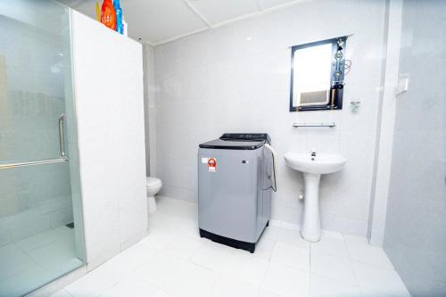 Un baño blanco con lavabo e inodoro. en Trinco Nathu Rest, en Trincomalee