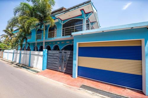un edificio azul con dos puertas de garaje en una calle en Trinco Nathu Rest, en Trincomalee