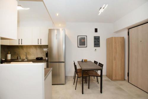 a kitchen with a table and a stainless steel refrigerator at Ilissos Harmony Apartment in Piraeus