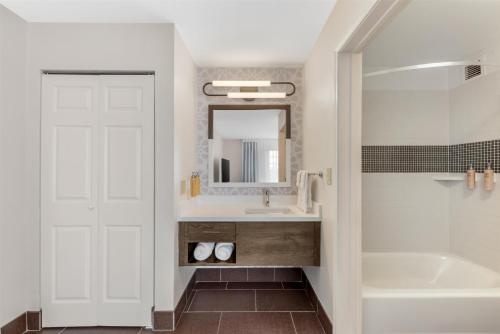 a bathroom with a sink and a tub and a mirror at Sonesta ES Suites Austin The Domain Area - Newly Renovated in Austin