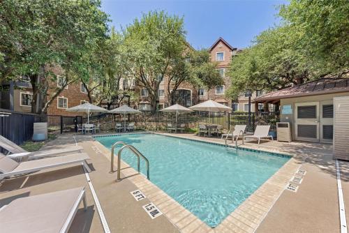 a swimming pool with chairs and umbrellas at Sonesta ES Suites Austin The Domain Area - Newly Renovated in Austin