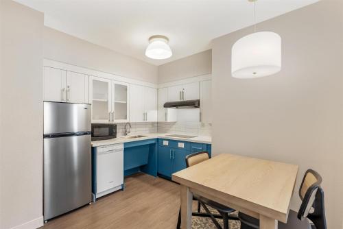 a kitchen with blue cabinets and a wooden table at Sonesta ES Suites Austin The Domain Area - Newly Renovated in Austin