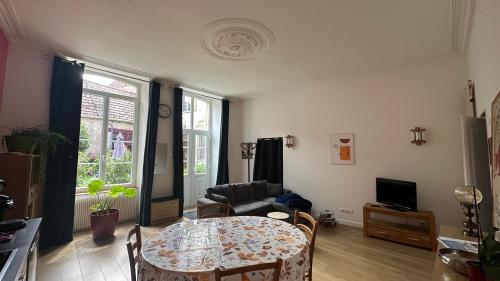 una sala de estar con una mesa y un sofá en Au Petit Relais, en Avallon