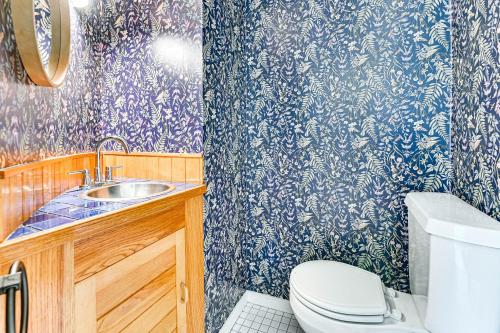 a bathroom with a toilet and a sink with blue and white wallpaper at 8 Mi to Tanglewood and Butternut Ski Spacious Home! in Housatonic