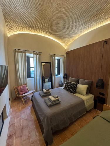 a bedroom with a bed and a chair in a room at Villa Duna Maria in Fuzeta