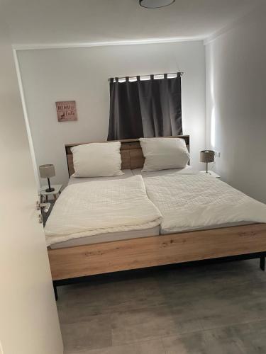 a bedroom with a large bed with white sheets and pillows at Black Forest apartment in Rottweil in Rottweil