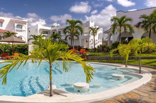 a palm tree in a pool in front of a building at Q Boutique Resort Malindi in Malindi