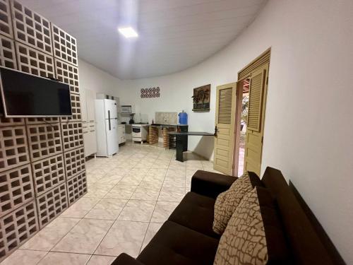 ein Wohnzimmer mit Sofa und eine Küche in der Unterkunft Juscelino Pousada lazer in Tibau