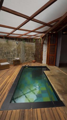 a swimming pool in a room with a wooden deck at RCH LUXURY HOTEL & POOL in Dibulla