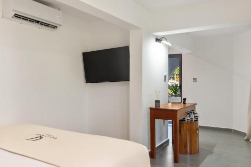 a living room with a couch and a tv on a wall at Q Boutique Resort Malindi in Malindi