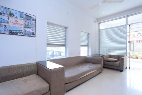 a living room with a couch and a chair at Super Townhouse Prince Palace in Trivandrum