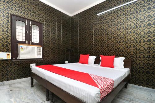 a bedroom with a large bed with red pillows at Hotel O Mall Residency in Amritsar