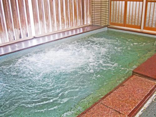 a small pool of water with a wooden fence at Matsunoyu in Matsue