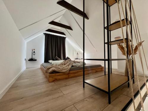 a bedroom with a bed and a ladder in a room at Silent Lake in Látrány