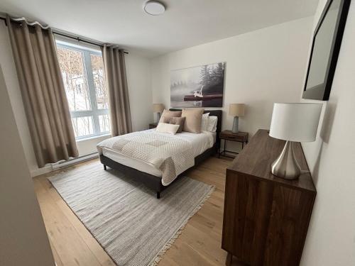 a bedroom with a bed and a large window at Le 800 de St-Jovite in Mont-Tremblant