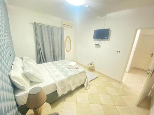 a small bedroom with a bed and a tv at Fournierje in Nzamata