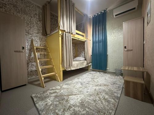 a room with a bunk bed and a ladder at Premium Hostel Atyrau in Atyrau
