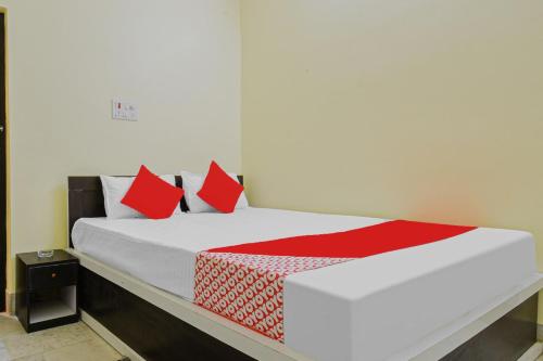 a bed with red pillows on it in a room at Hotel O Harsh in Khagaul