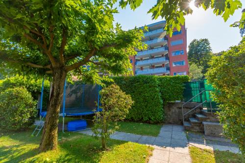 a tree with a swing and a building in the background at La Perla Sul Lago - Happy Rentals in Paradiso