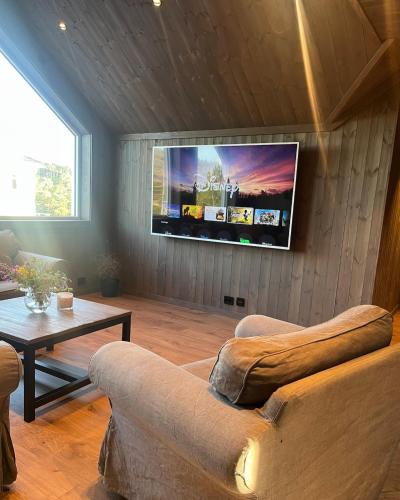 a living room with a couch and a flat screen tv at Ny leilighet 5 min fra Dyreparken in Lillesand