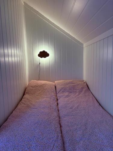 a bedroom with a bed with a light on it at Ny leilighet 5 min fra Dyreparken in Lillesand