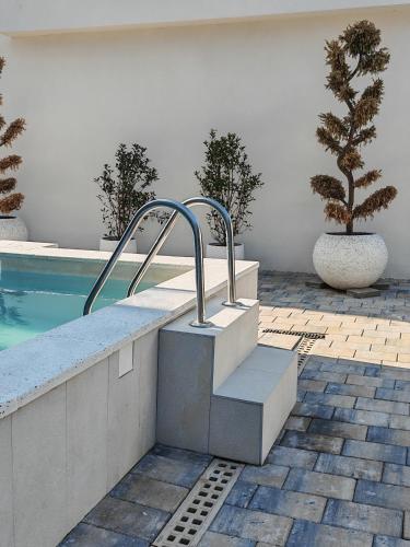 a swimming pool with a stairway next to a sidx sidx sidx at POOL RESORT Vila Lena - Lux residence apartman 1 in Vrdnik