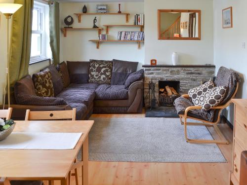 ein Wohnzimmer mit Couch und Kamin in der Unterkunft Willow Cottage in Newlyn East