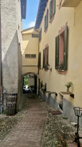 an alley between two buildings with an archway at Locanda Orticello in Cremolino