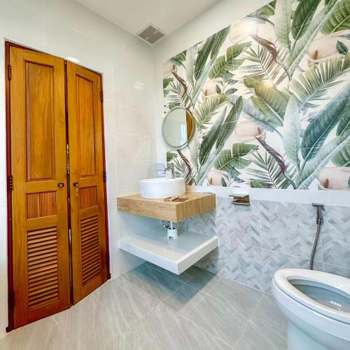a bathroom with a sink and a toilet with a mural at Mimi Pool Villa Chiangmai in Chiang Mai