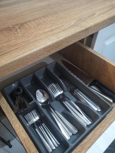 a tray with silver utensils in a drawer at Yan's House apartament 2 camere decomandat in Drobeta-Turnu Severin