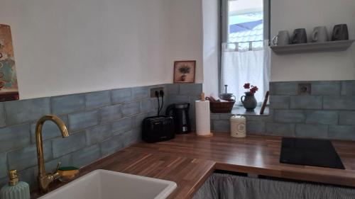 a kitchen with a sink and a counter with a window at Teljesen felszerelt kis ház, saját udvarral :) - Notre petite maison in Pécs
